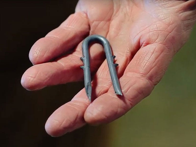A man holding a fencing staple