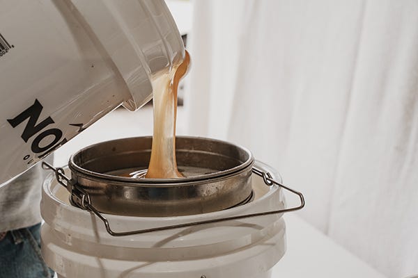Honey pouring into a strainer. 