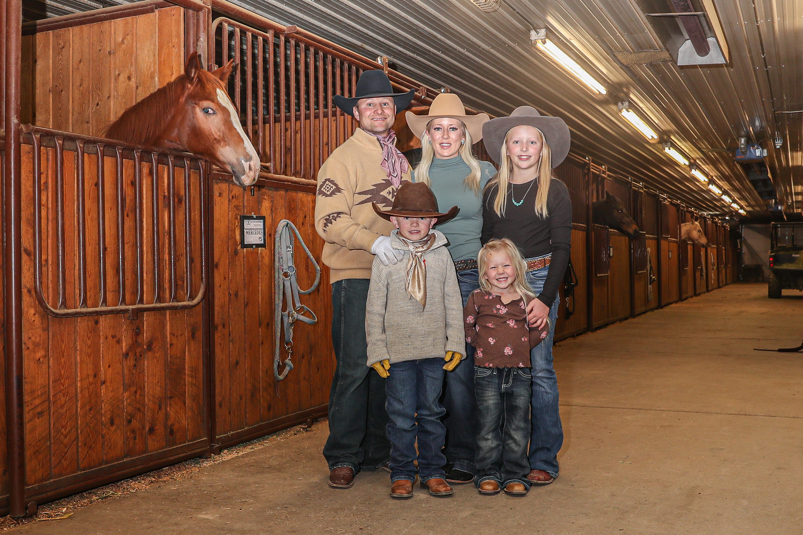 Jesse, Lindsay, and their three children pose for a photo in their barn