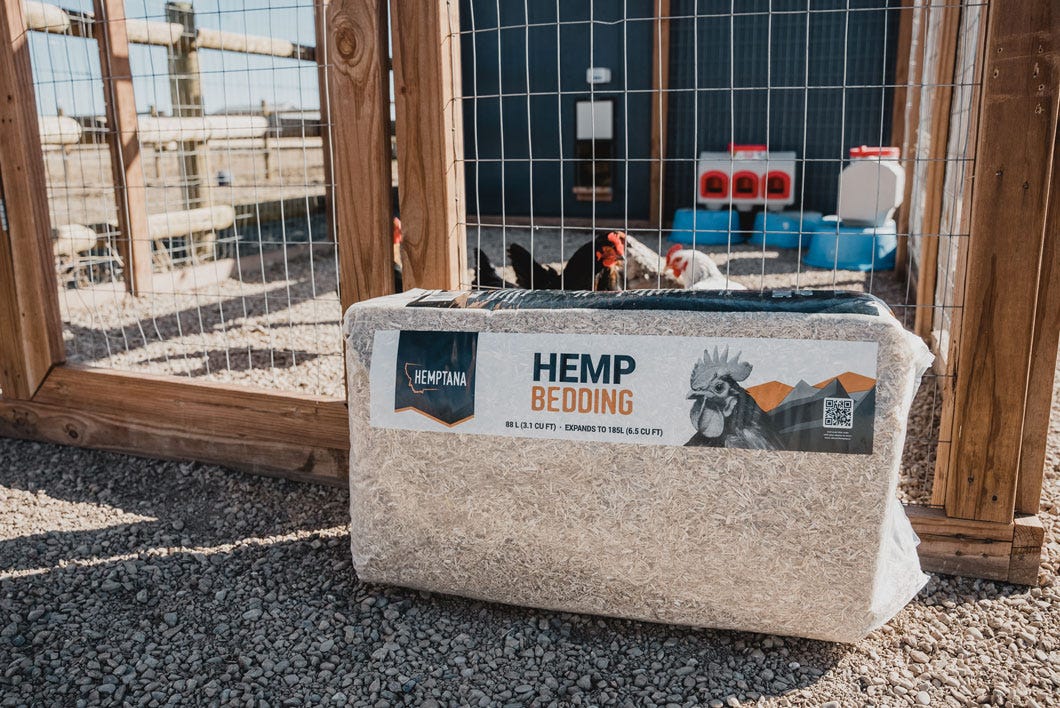 An unopened bag of Hemptana hemp bedding sits outside of a chicken coop fence