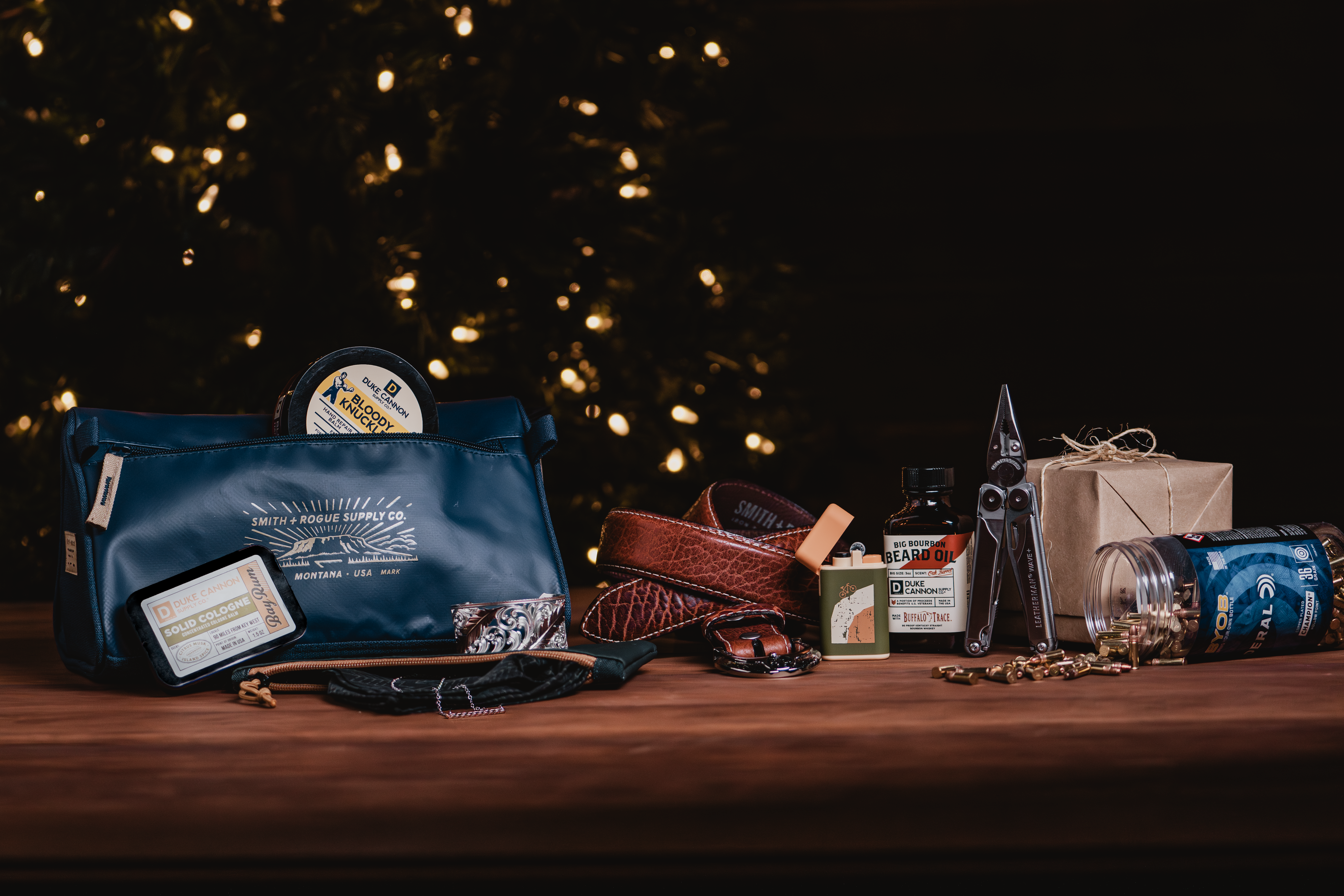 a festive lineup of several small gift ideas in front of a dimly lit christmas tree