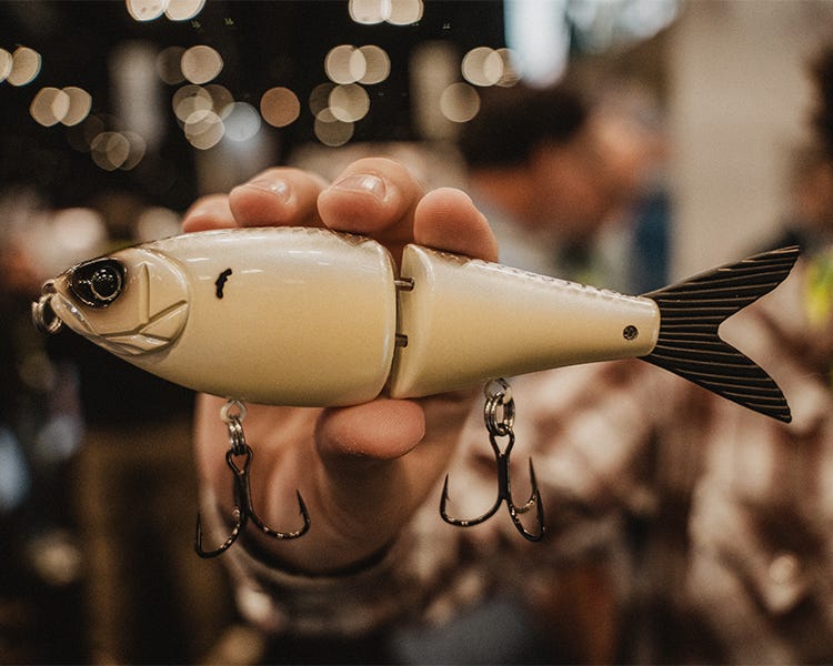Custom-designed Tater Hog x Strike King multi-jointed swimbait in a lifelike bass colorway, showcased on a display stand at ICAST 2025.