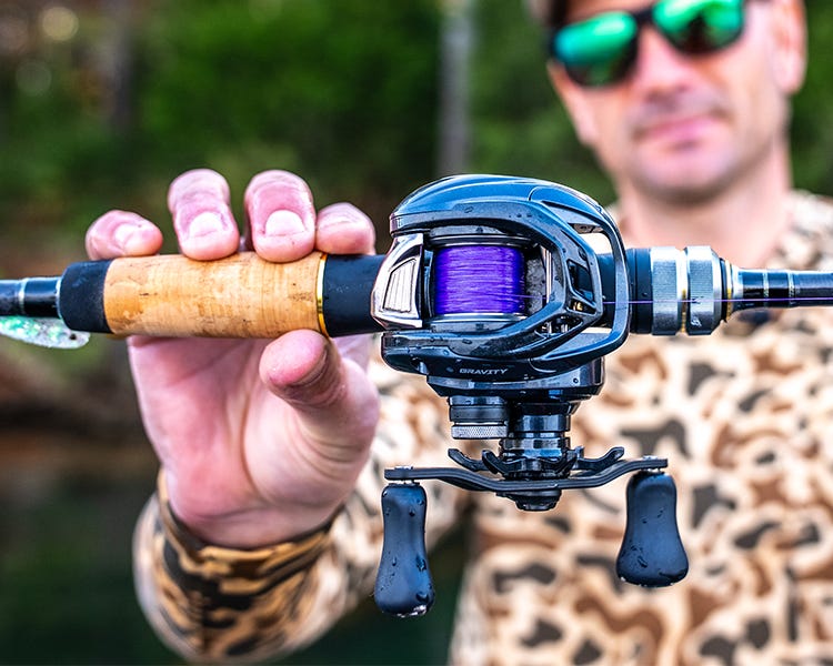mikey ballz holding up a rod and reel combo with the purple BFS performance braid spooled up 