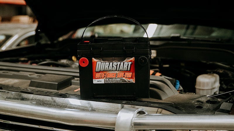 A durastart battery sitting under the hood of a truck