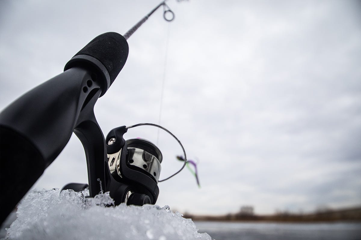 An ice fishing rod propped up on a pile of snow 