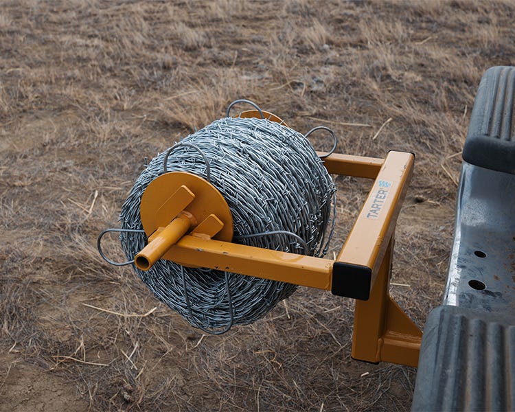 Roll of OK Brand Premium Barbed Wire on a Tarter Wire Unroller