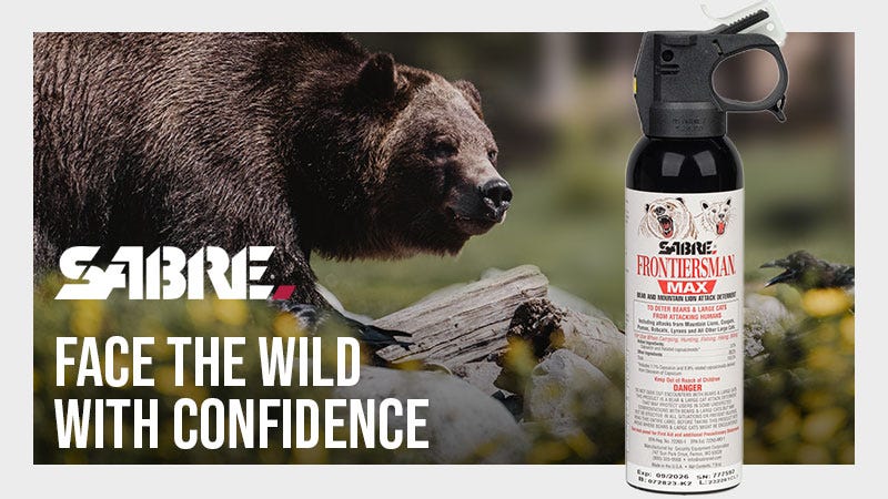 Bear with the text: SABRE Face the Wild with Confidence. Can of Bear Spray in the foreground. 