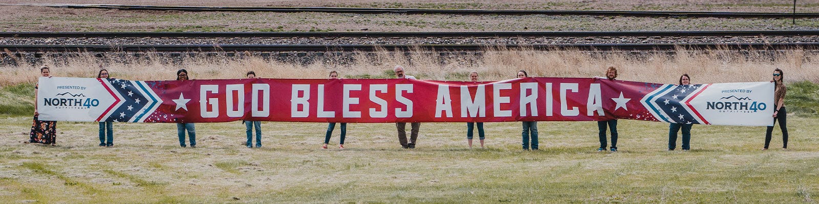 god bless america banner held up in field