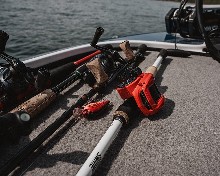 several rods and reels on the deck of bass boat with a craw color crankbait 