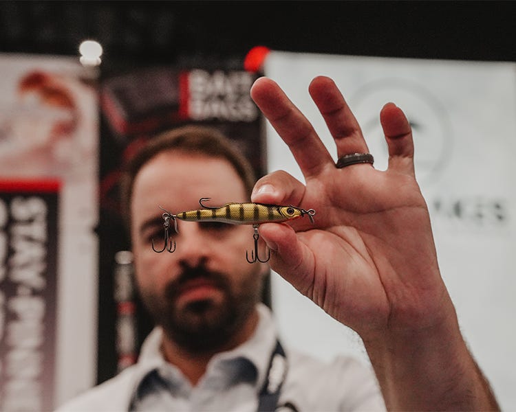 dan holding up the new stay pinned spybait by great lakes finesse at the icast 2026 show