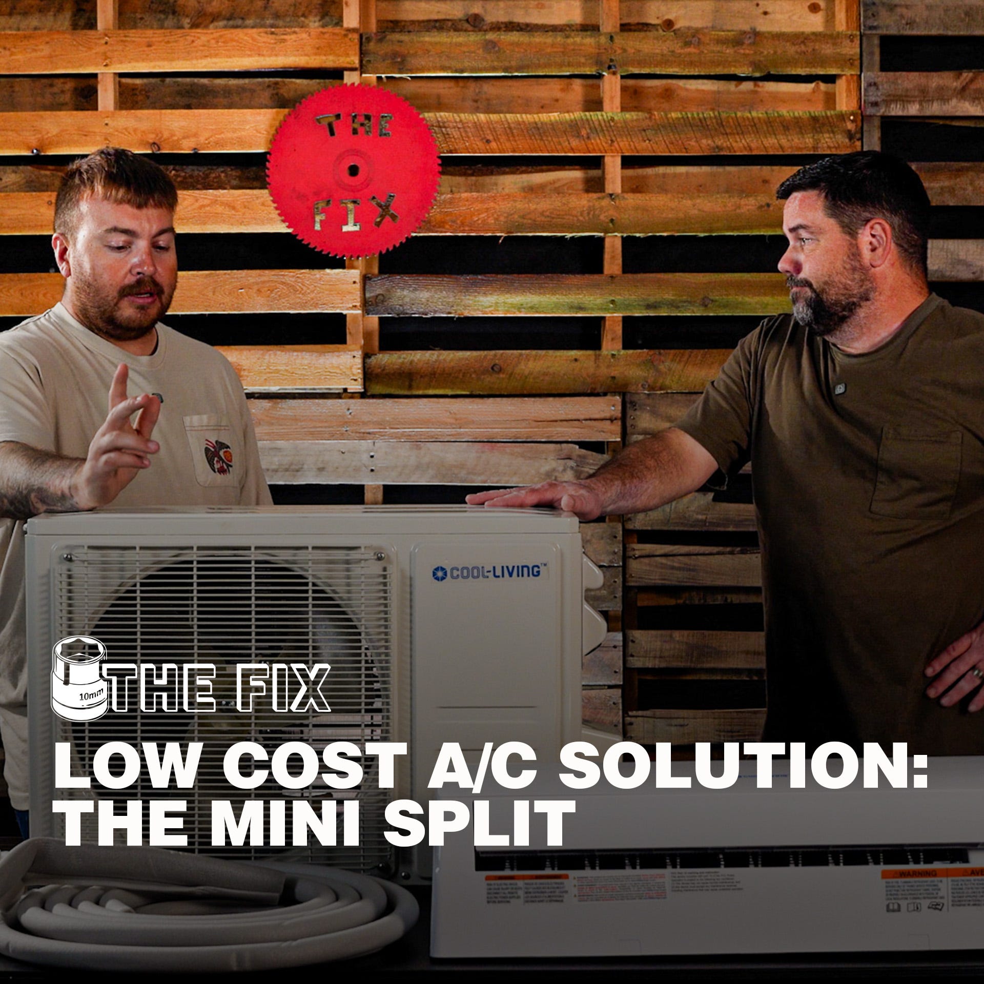 Two people discuss a ductless mini split air conditioning system in a workshop with a wood pallet wall backdrop. An outdoor condenser unit, indoor air handler, and coiled line set are displayed on a table. Overlay text reads: &ldquo;THE FIX &ndash; LOW COST A/C SOLUT