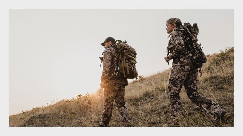 Two People Wearing Hunting Clothing and Hunting Packs