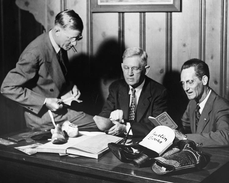 Earl Justin, John Justin Sr. and Sam Justin sitting behind a desk (Courtesy of Justin Boots)