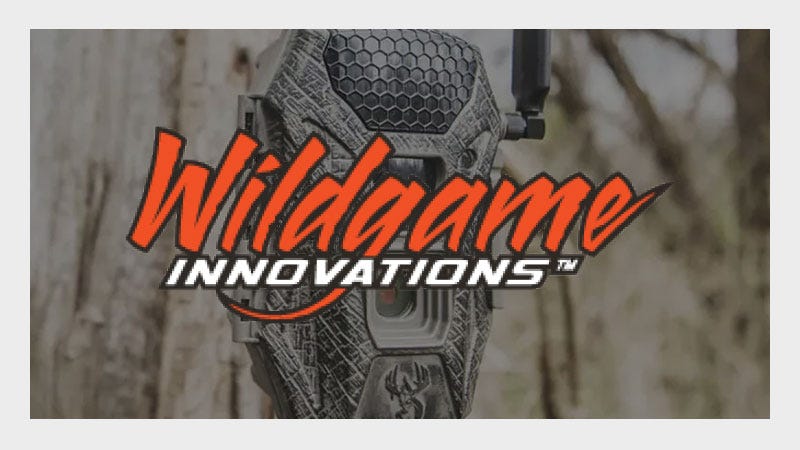 A trail camera with a rugged design is mounted on a tree. The bold, red "Wildgame Innovations" logo overlays the image, conveying an outdoorsy feel.