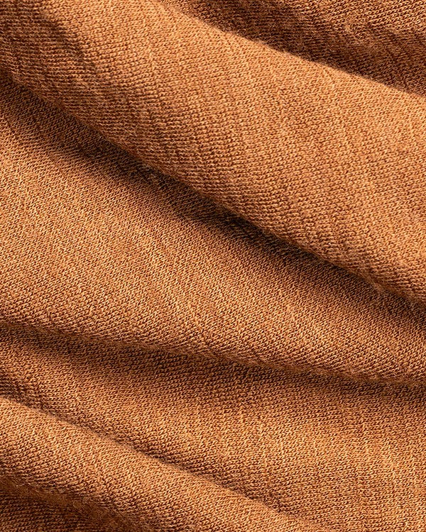 Close-up of brown Smith + Rogue Skoltec baselayer fabric showing textured stretch knit material and soft folded detailing.