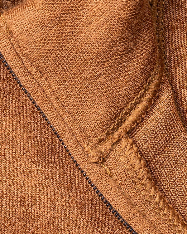 Close-up of Smith + Rogue Skoltec baselayer fabric featuring reinforced seam stitching and soft thermal knit material in a brown colorway.