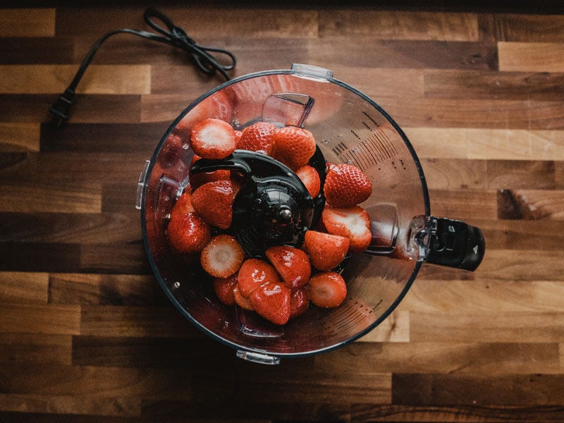 Top down view of strawberries in a blender ready to be processed