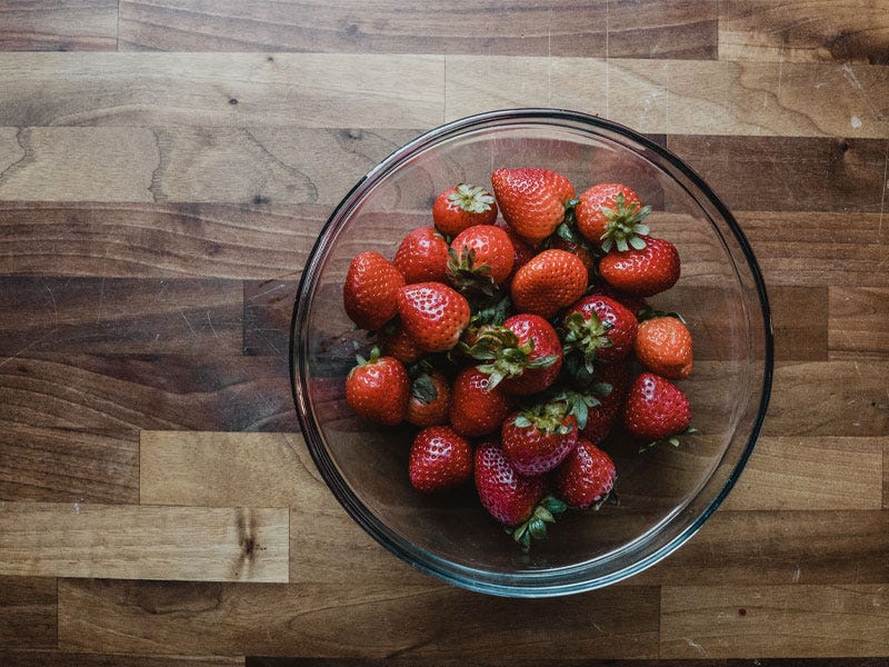 Fresh red Florida strawberries in a bowl on a clean butcher block