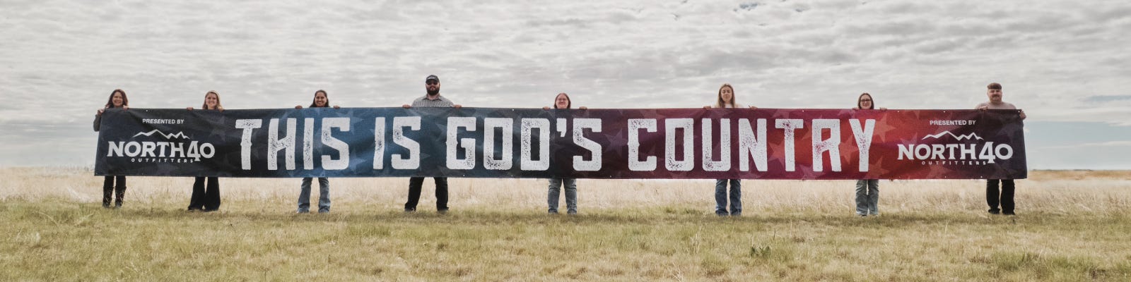 god bless america banner held up in field