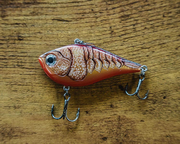 rapala lipless craw color crankbait sitting on a wooden table 