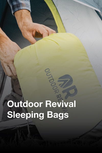 A collection of colorful outdoor revival sleeping bags arranged on grass, showcasing various designs and patterns.