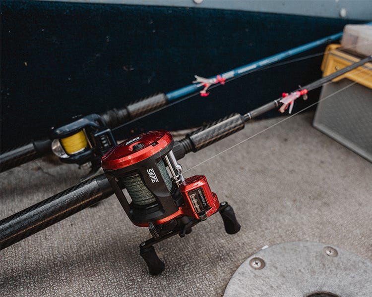 two trolling rod and reels set up laying against the deck, rigged up and ready to go, swate zephyr, swate local, swate fiberhammer, daiwa lexa