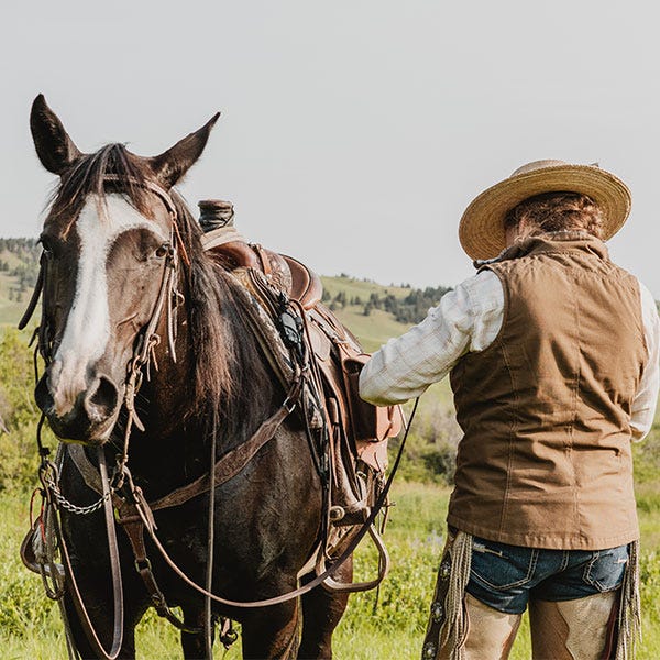 woman standing with horse in field