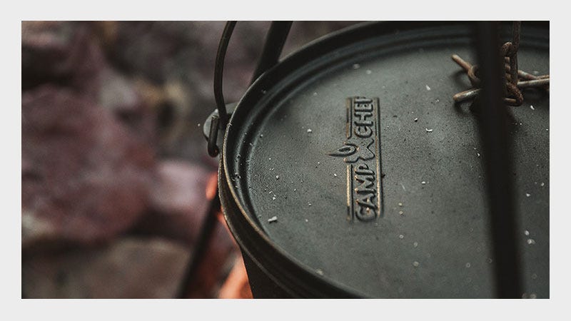 A black cooking pot featuring a sturdy metal handle for easy lifting and pouring.