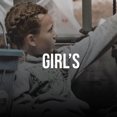 A girl sits in a truck, with the word "girls" displayed prominently on the side.