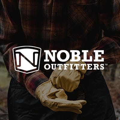 man pulling on gloves with a white noble outfitters logo in the front