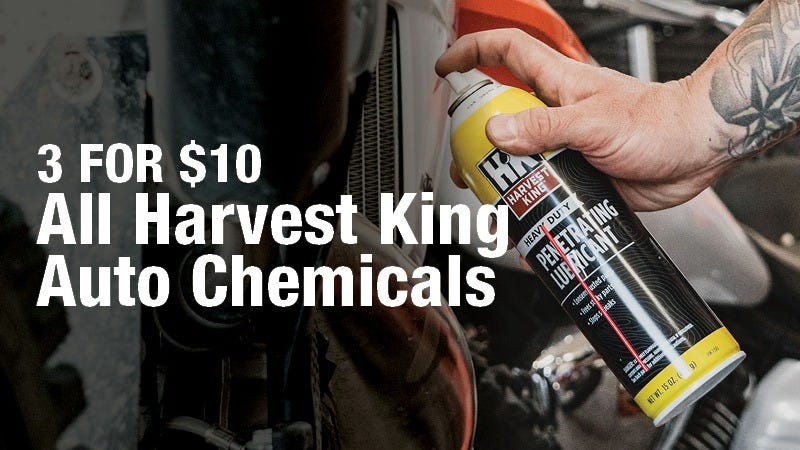 A tattooed person sprays a can of Harvest King heavy duty penetrating lubricant onto a motorcycle part, with large text stating "3 FOR $10 All Harvest King Auto Chemicals" on the left side.