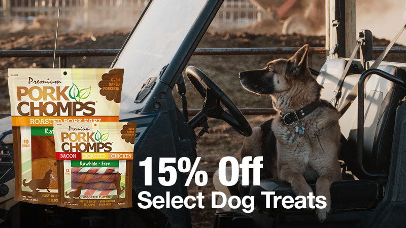 A German Shepherd sits in the driver&rsquo;s seat of an outdoor vehicle, with two bags of Pork Chomps dog treats displayed on the left and large white text that reads "15% Off Select Dog Treats."